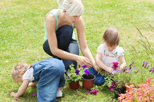 Gardener pruning shrubs in a Chessington garden